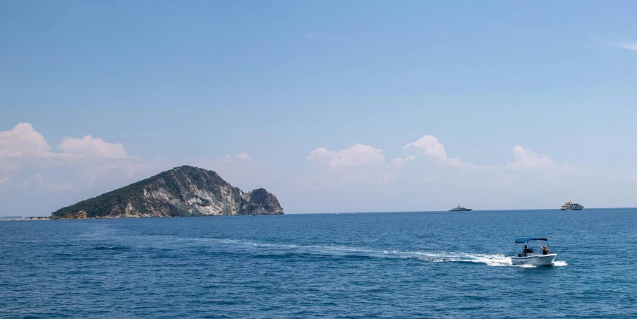 a boat in the water with two small boats nearby