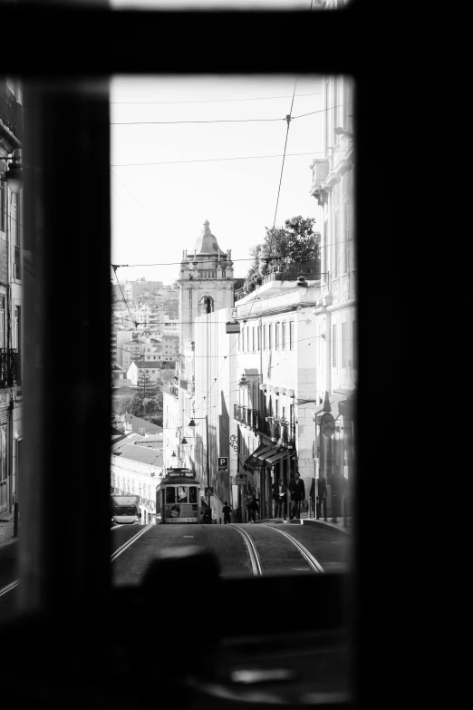 some vehicles are driving down the road in a narrow city street