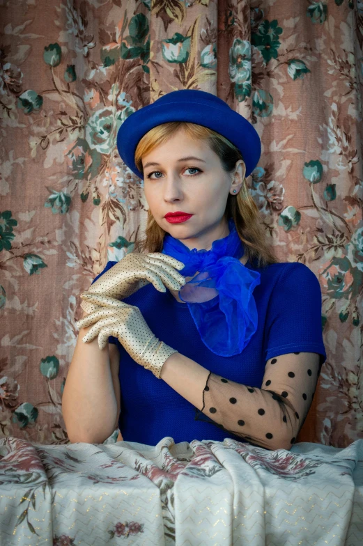 a woman is wearing white gloves and a blue top