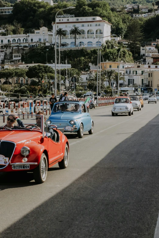 a group of old time cars traveling down a street