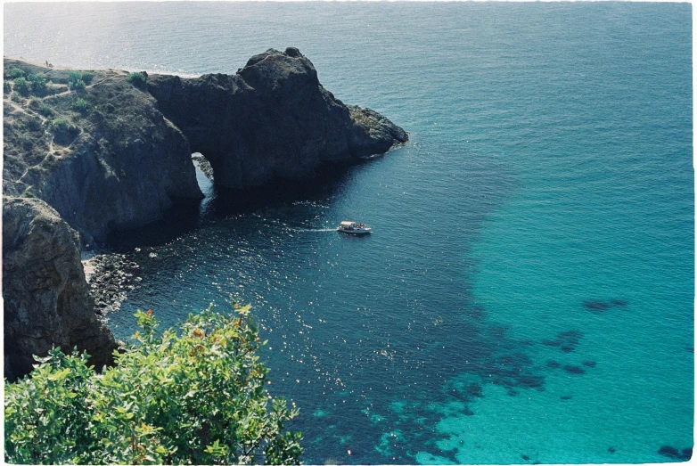 a beautiful ocean with an old rock and boat