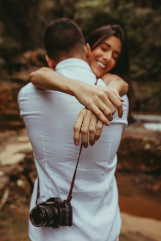 a man is hugging a woman holding his camera