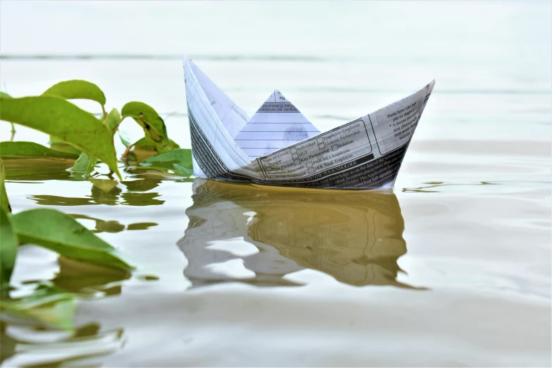 the paper boat is floating in the water