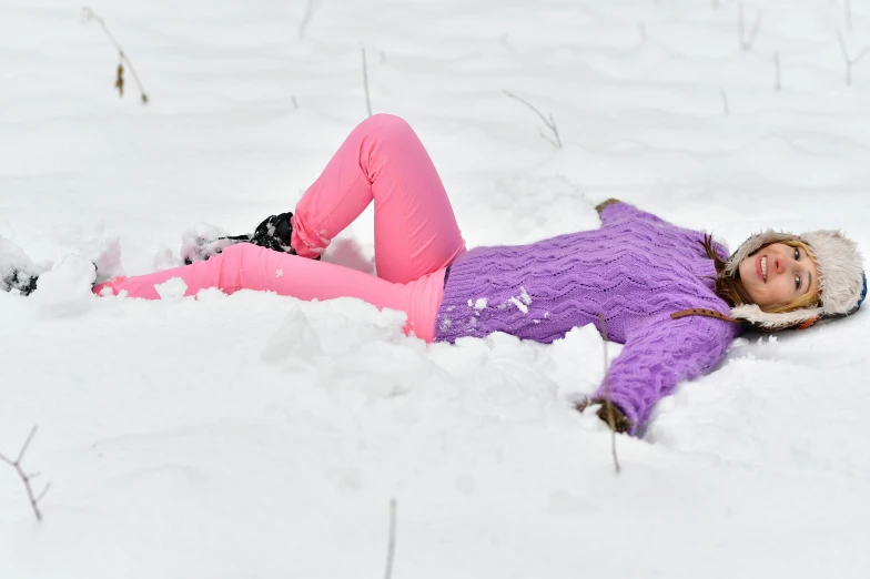 a female snow skier laying down in the snow