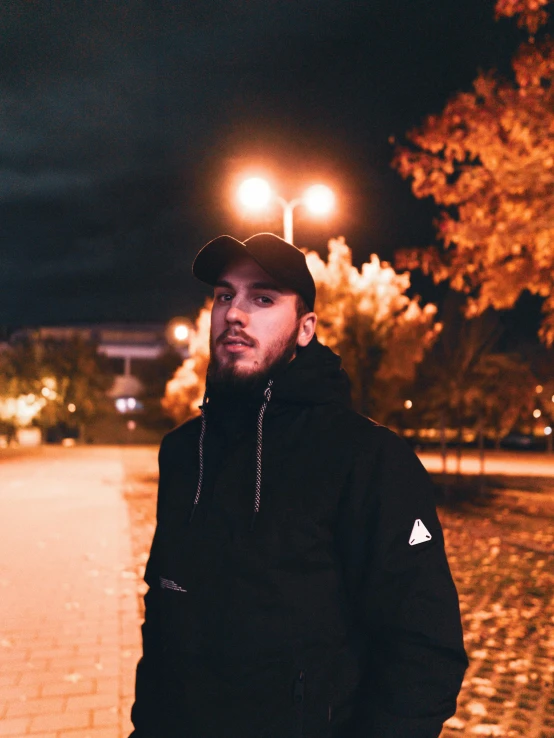 man in hat standing near street at night