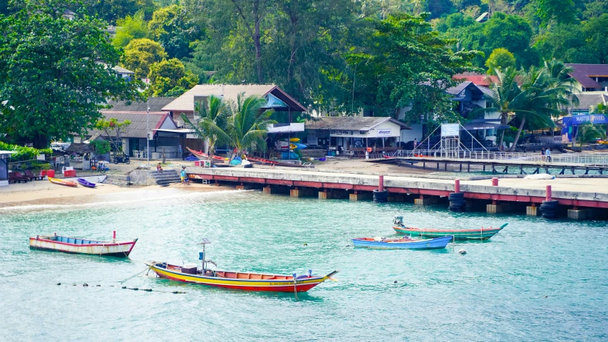 boats docked in the water next to a small pier