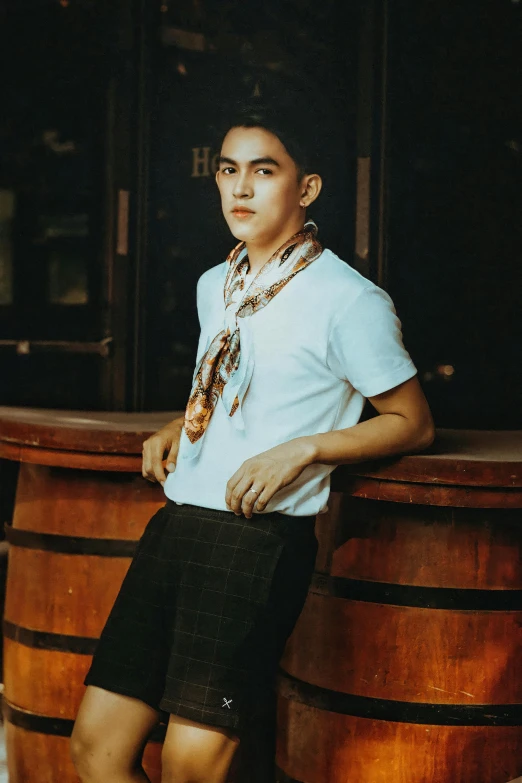 a man poses at a small wooden barrel with chains around his neck