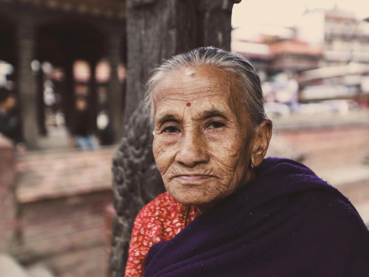 a woman standing next to a wall in front of a building