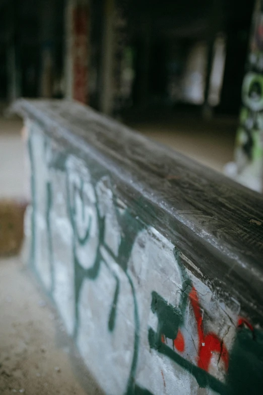 graffiti on a bench at a park with stairs behind it