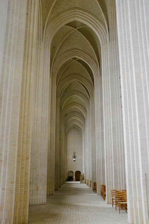 rows of benches lining a long hallway of a large cathedral