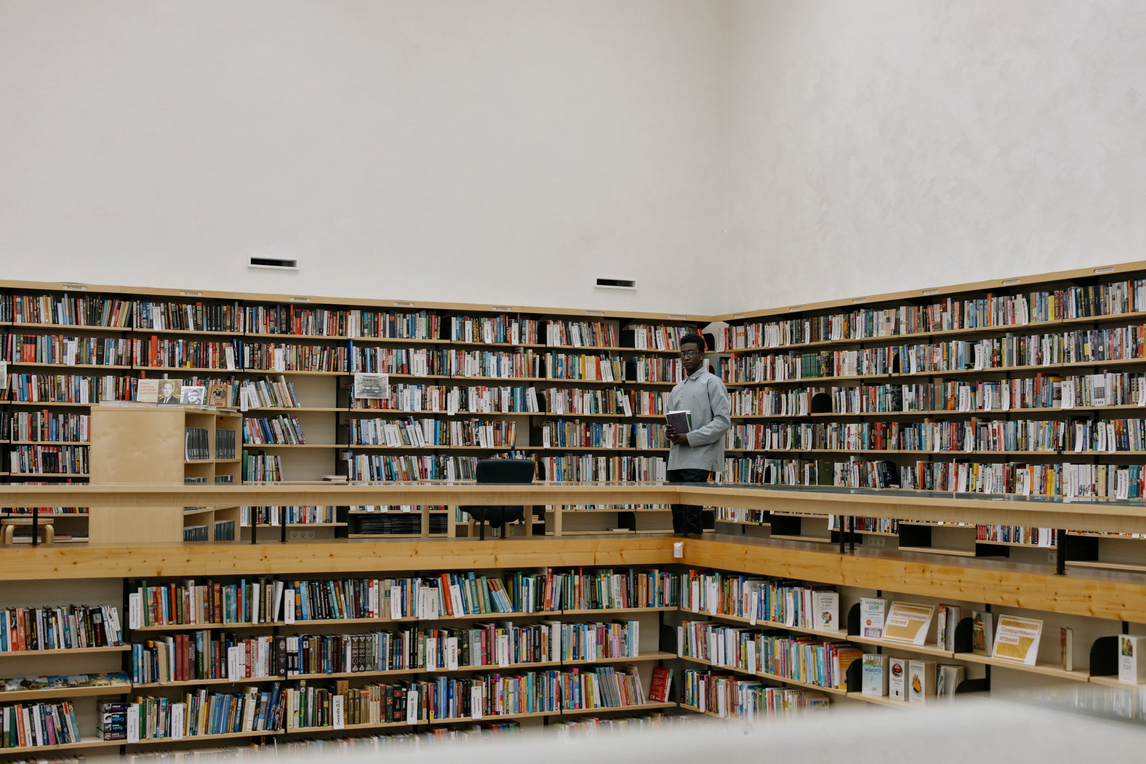 a man standing between two rows of books in a liry