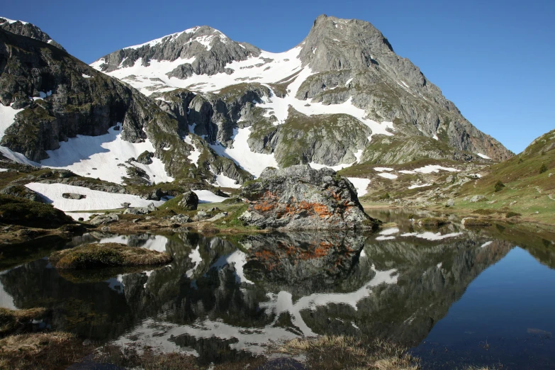 snow capped mountains are reflected in still water