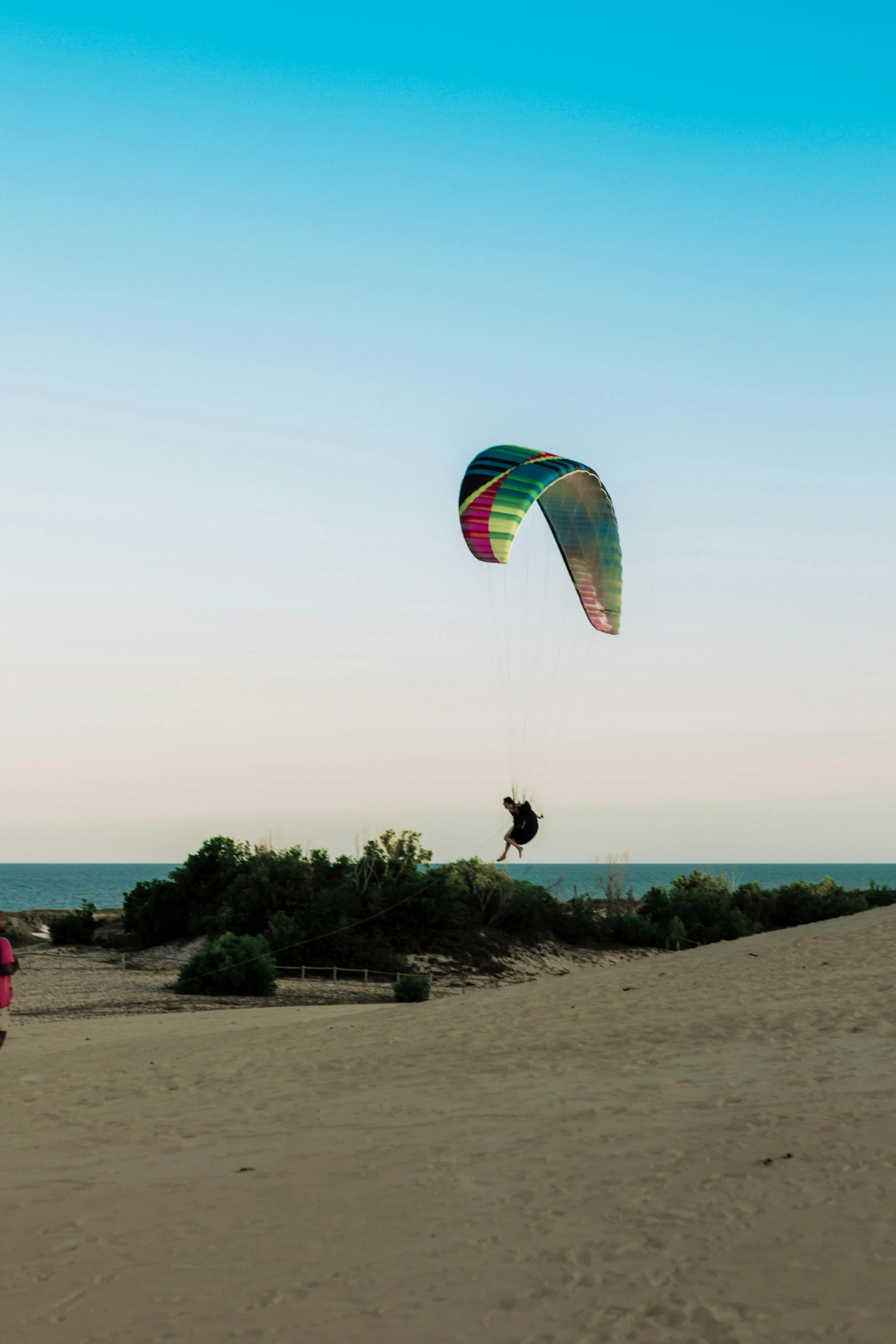 a person on the sand holding onto a kite