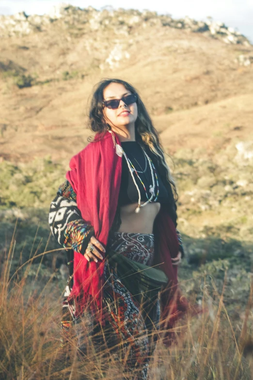 woman posing with head scarf and sunglasses in grassy area