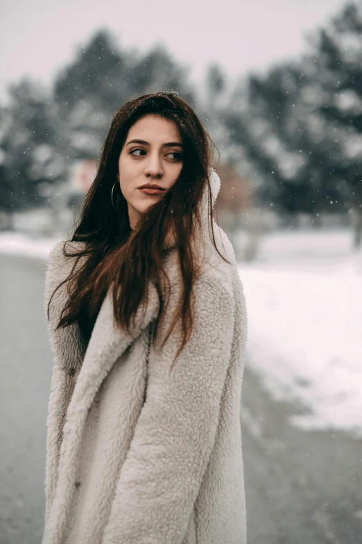 a woman with long hair is standing in the snow