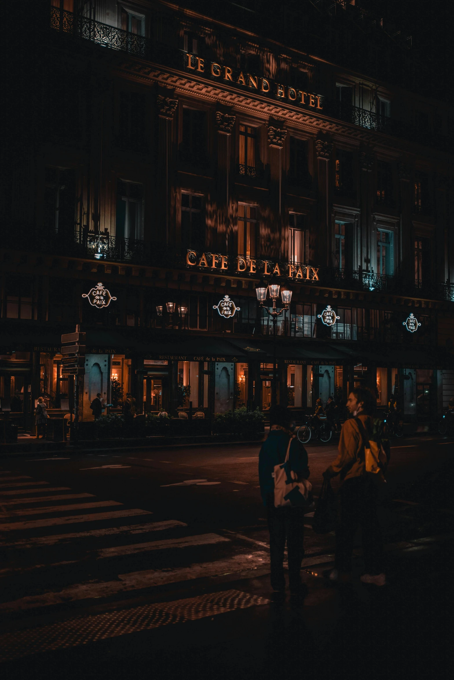 a group of people standing outside of a building at night