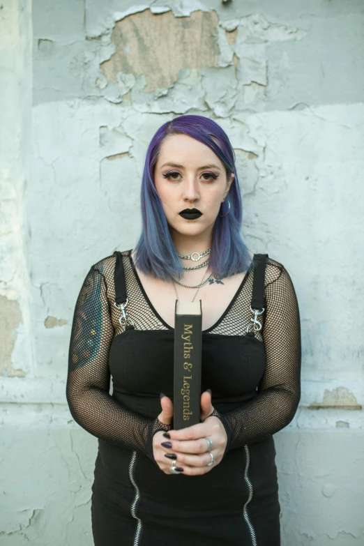 a girl with purple hair holding a book in her hands