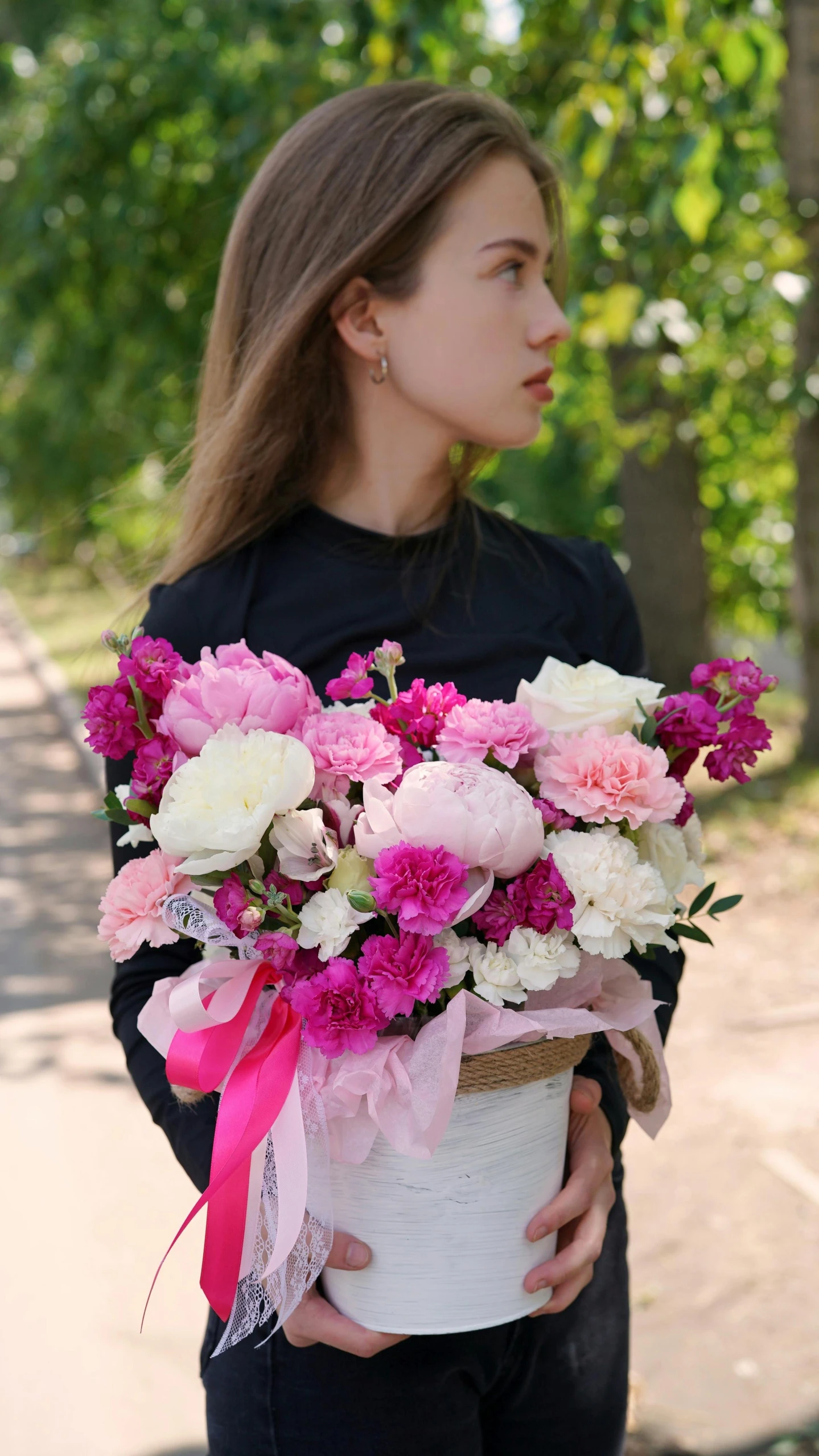 the girl is holding a flower arrangement in a basket