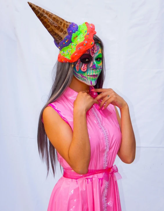 a girl wearing a pink dress and cone nose mask