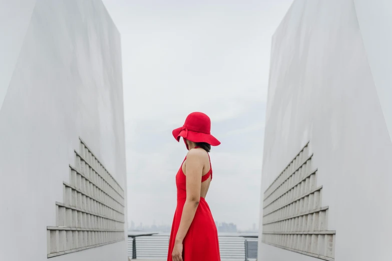 the woman is walking alone in the red hat