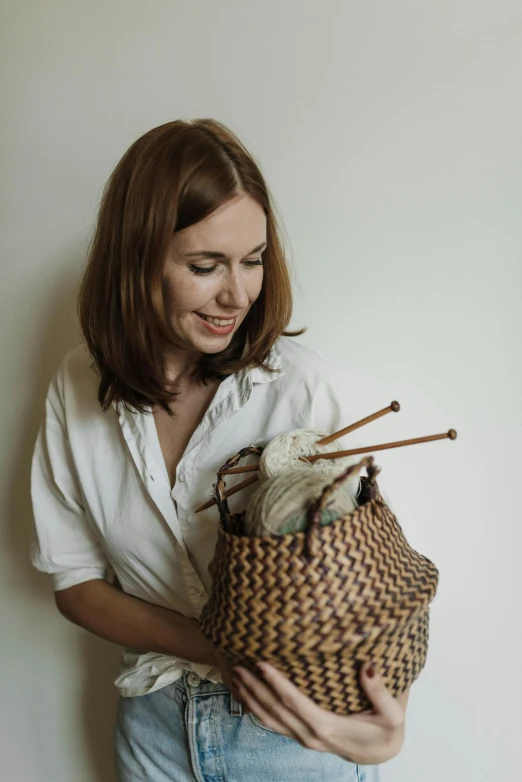 a woman holding a woven basket with bamboo sticks