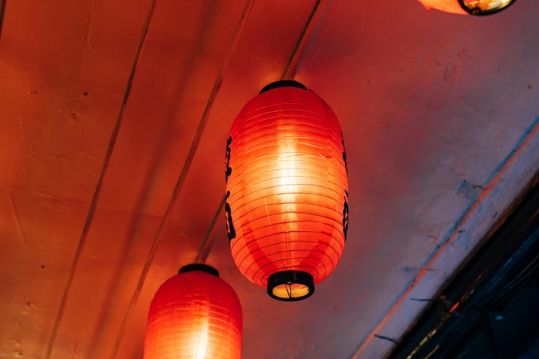 two lamps glowing red in front of an orange wall