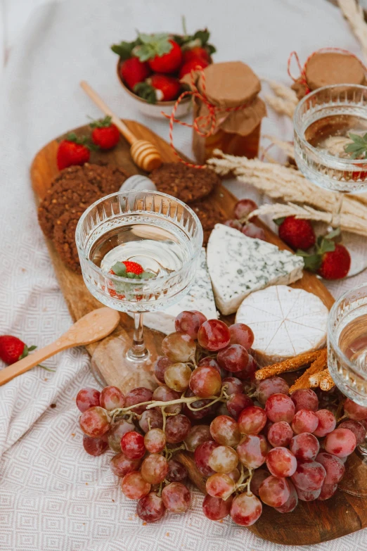 wine glasses and bread with some red fruits next to them