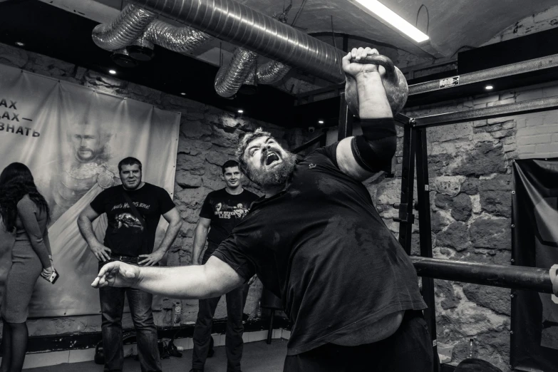 a man holding up his fist standing in a room with other people