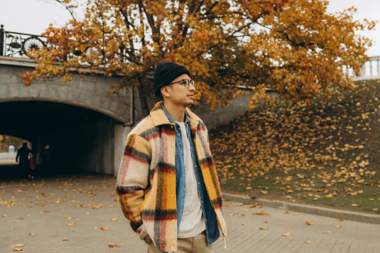 a young man standing on the sidewalk and looking up