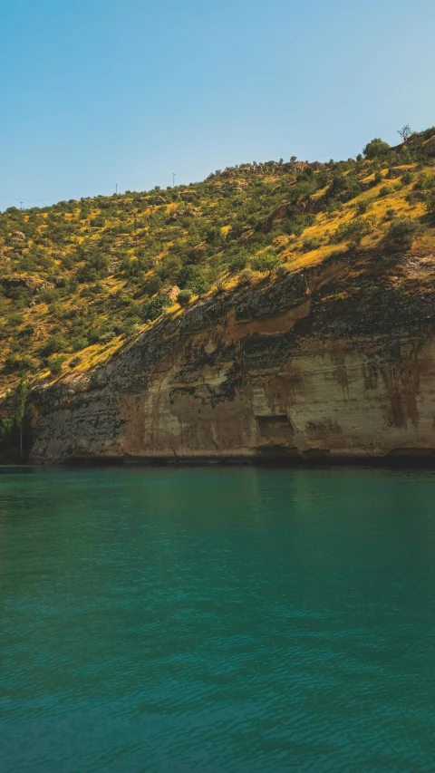 a boat is in the water near a mountain