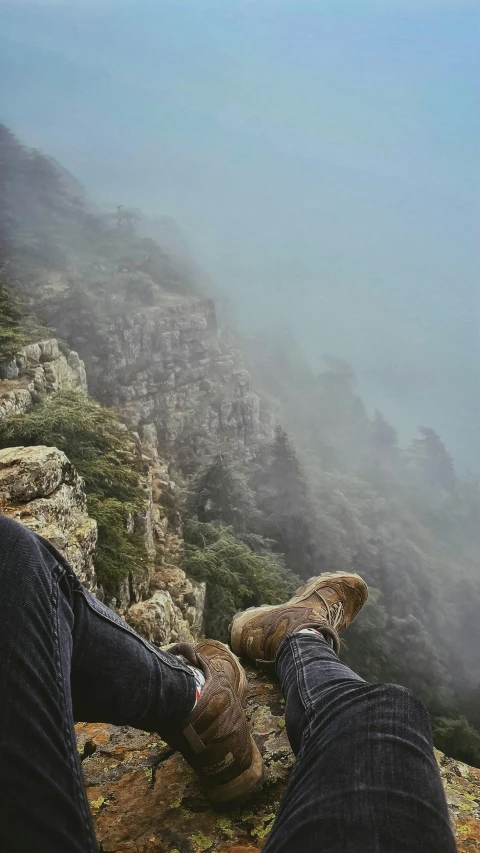 man with stuffed bear laying down on rocky mountain side