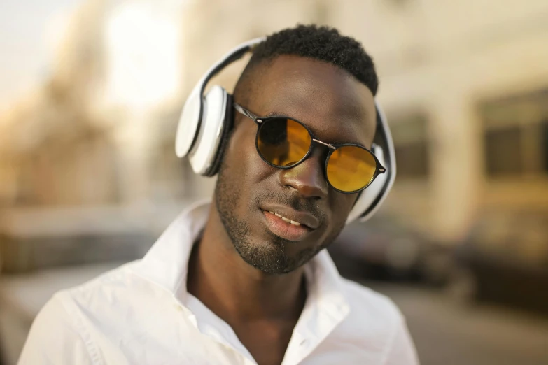 a man with sunglasses and ear buds wearing headphones