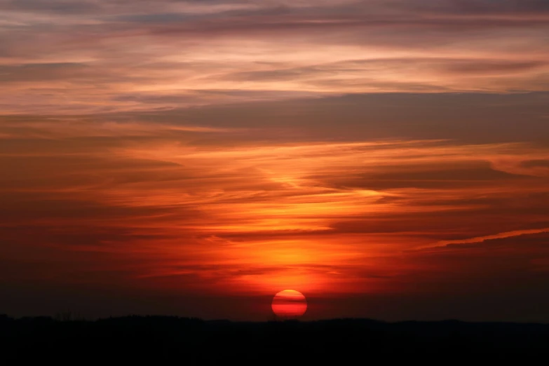 the sun is setting in the sky over the field