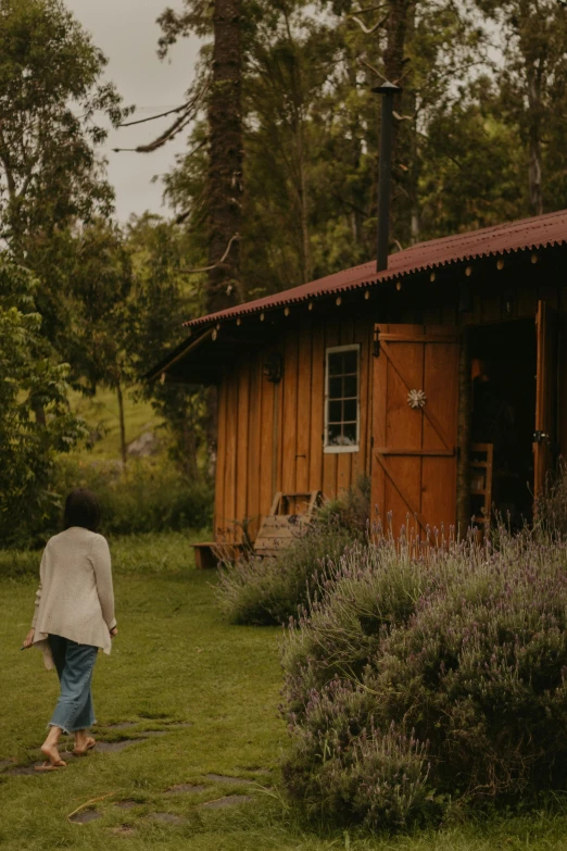 an image of a woman walking toward a cabin