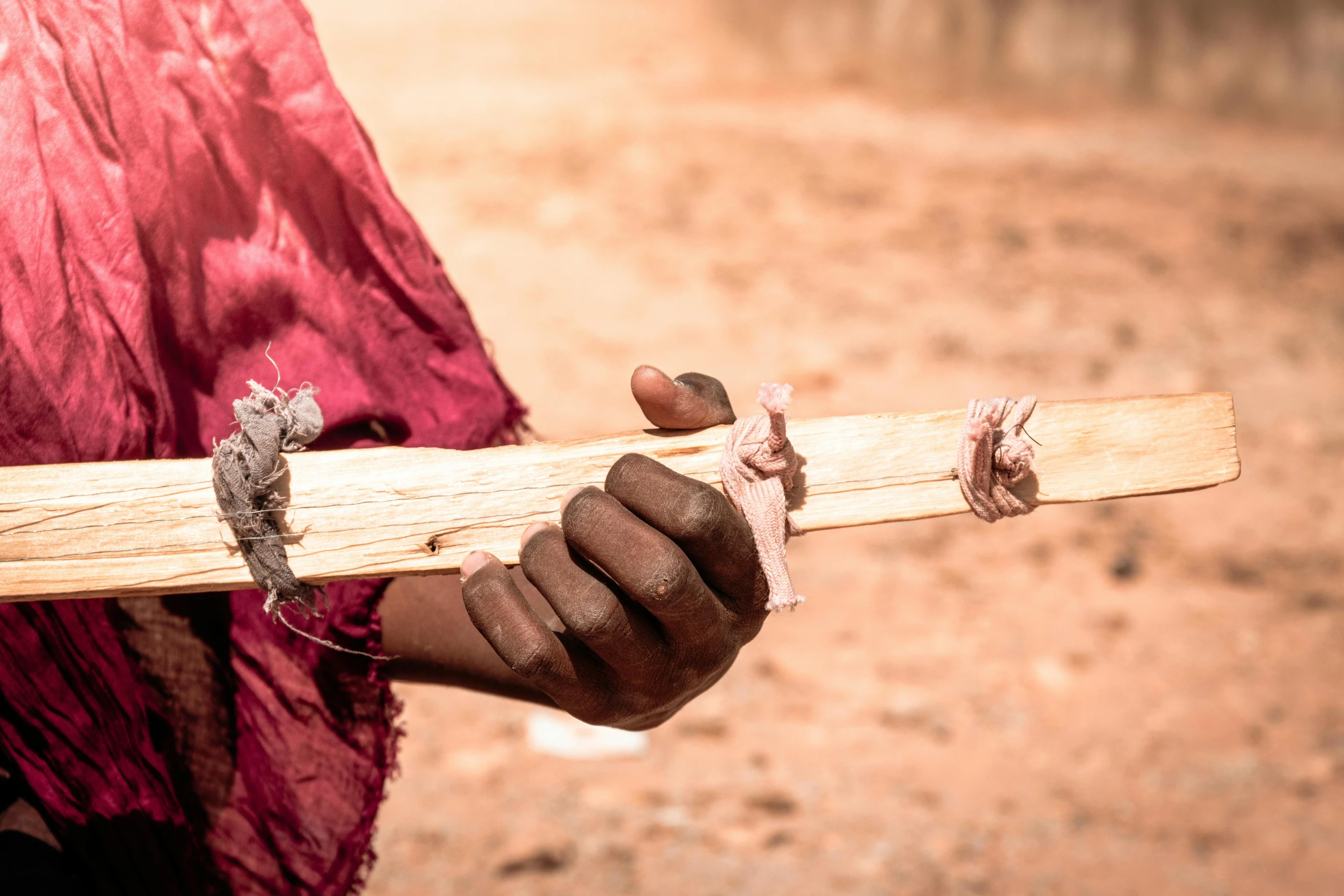 a woman holding a wooden stick on her right arm