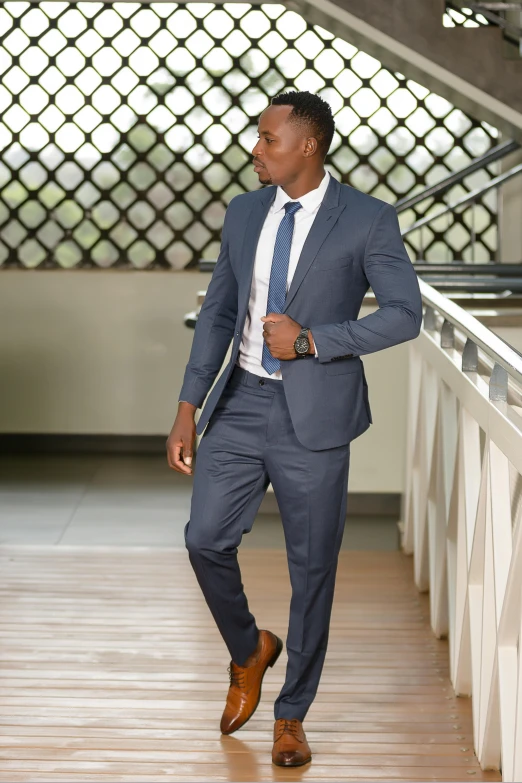 a man in a business suit walks along a handrail