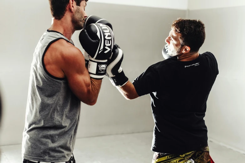 two men boxing in the ring and wearing gloves