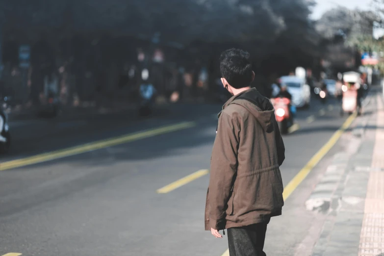 man standing on the side of the road waiting for traffic