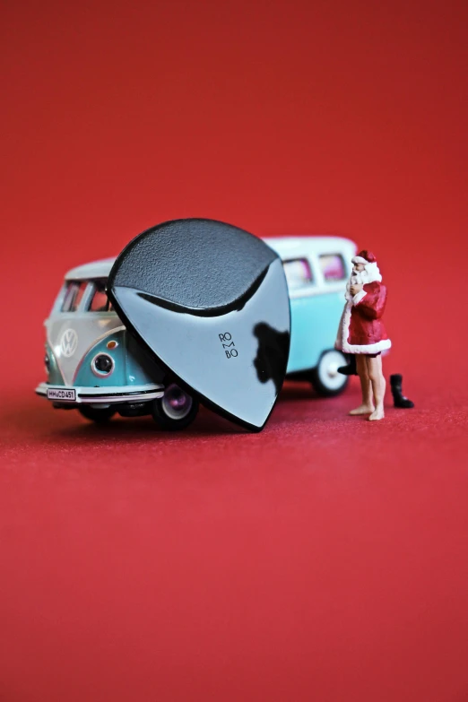 a toy car with a woman standing beside it