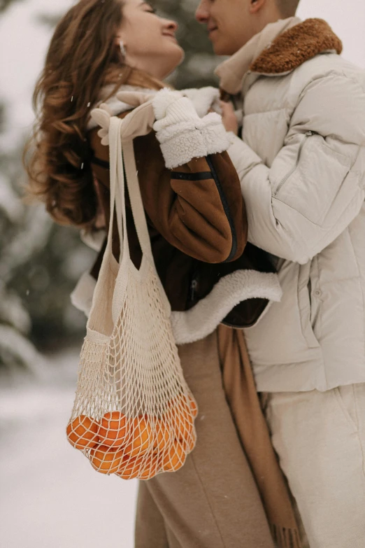 the man and woman are standing close together in the snow