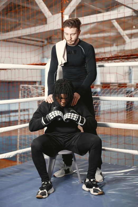 two men are posing with one man in the ring