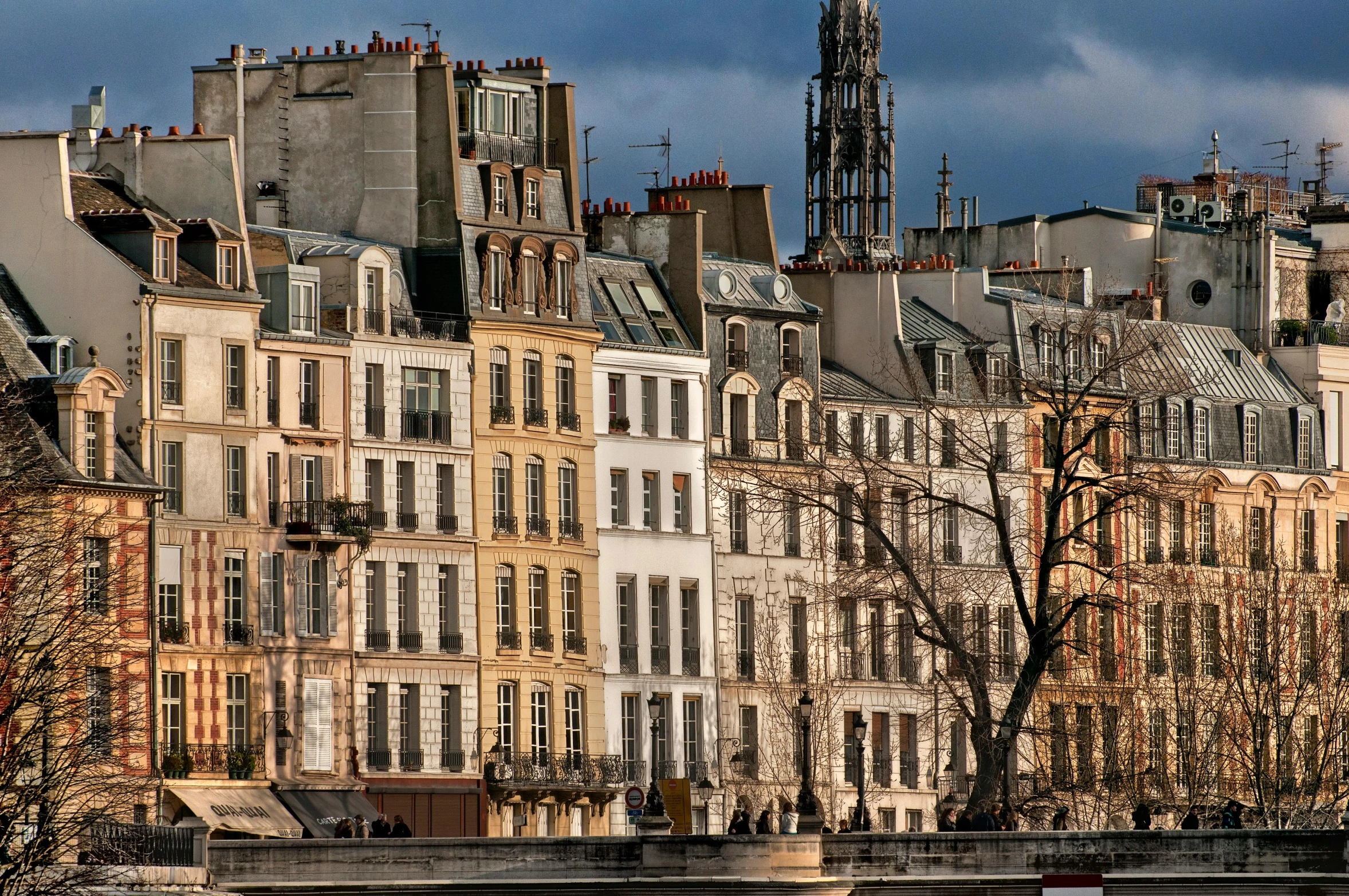 buildings line the river and a tower in the distance