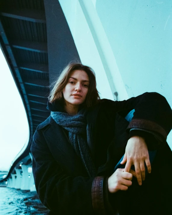 a man posing for a picture while holding onto the side of his jacket