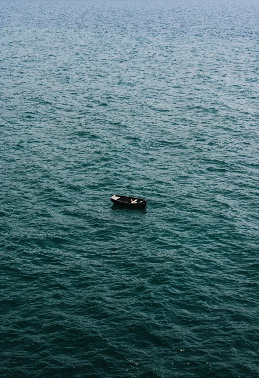 two people are riding in a boat out on the ocean