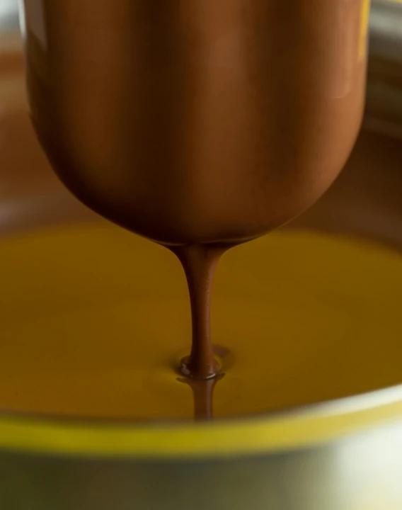 a close up of a chocolate sauce being poured into a bowl