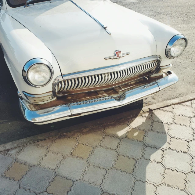 an old fashioned car parked on a side walk