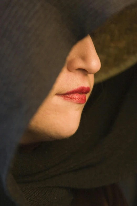 close up po of woman with red lipstick wearing winter clothes