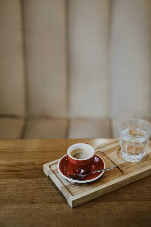 a wooden tray with a glass and a coaster on it