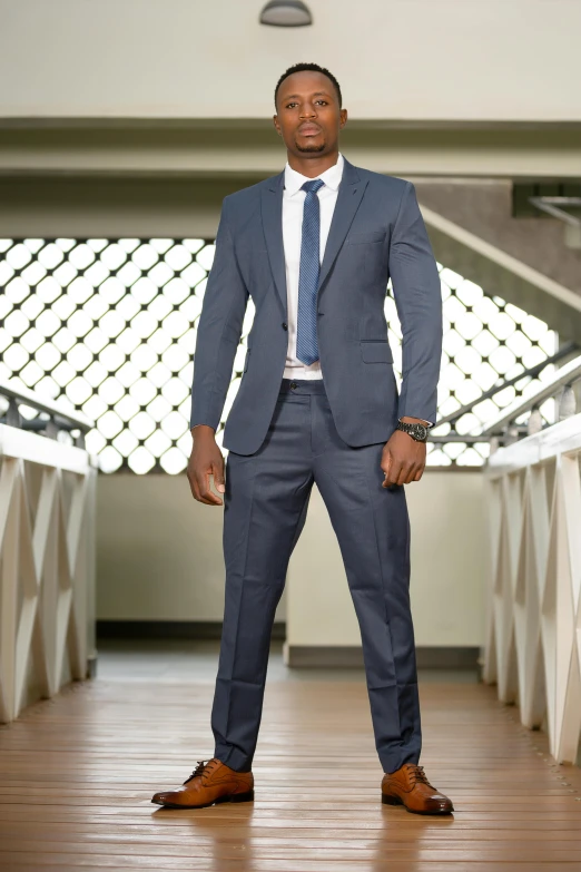 a man in a suit is standing by some stairs