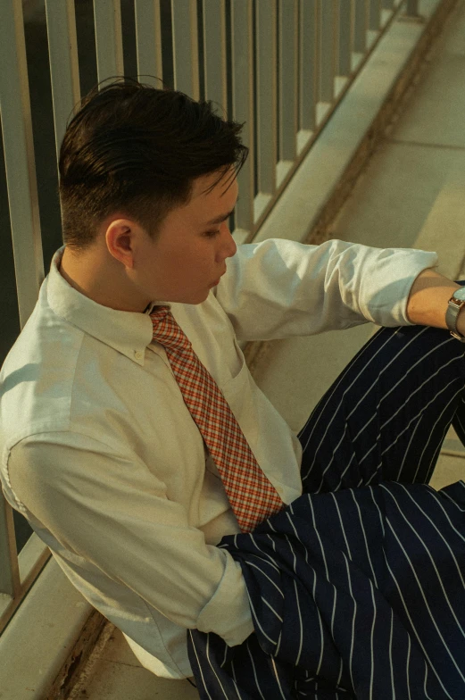 man in suit and tie sitting on stairs